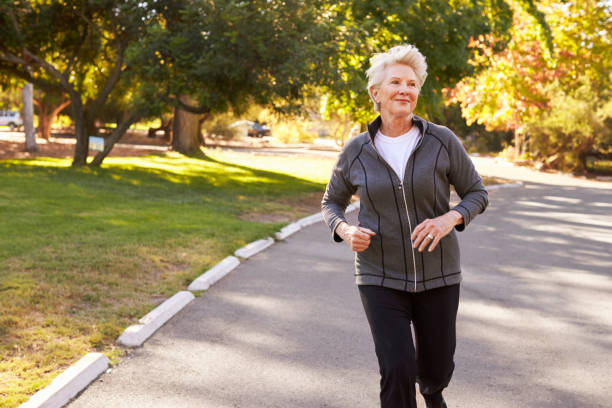 istock Front View Of Senior Woman Jogging Through Park 660353236