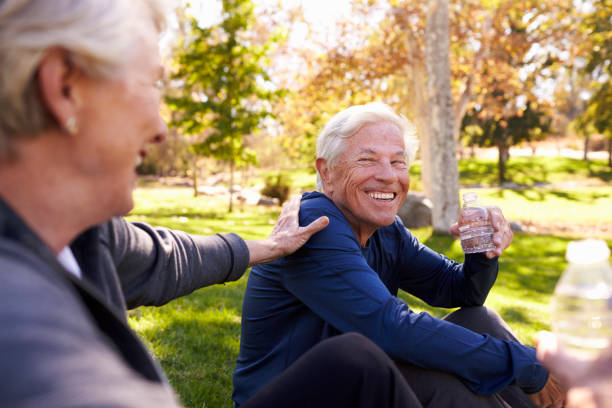 istock Senior Couple Resting After Exercising In Park Together 660353262