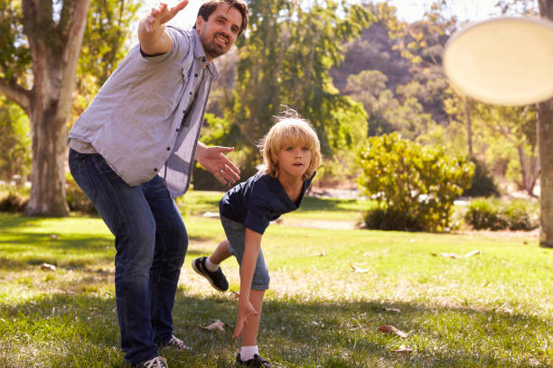istock Father Teaching Son To Throw Frisbee In Park 660353344