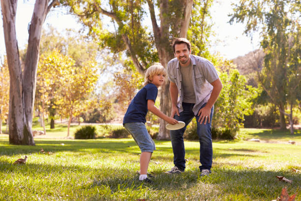 istock Father Teaching Son To Throw Frisbee In Park 660353366