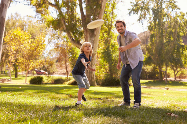 istock Father Teaching Son To Throw Frisbee In Park 660353384