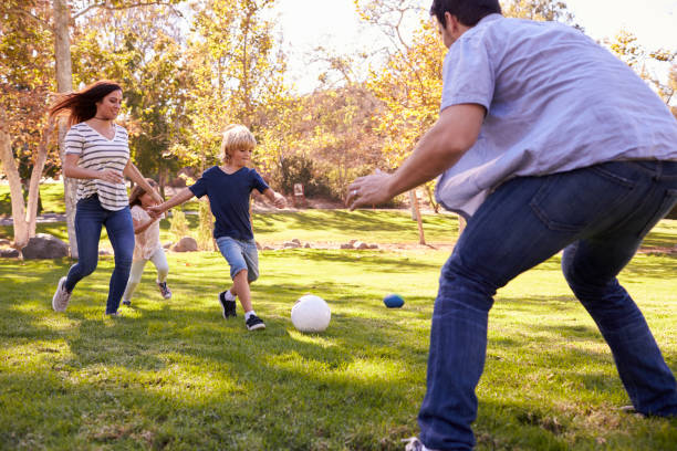istock Family Playing Soccer In Park Together 660353386