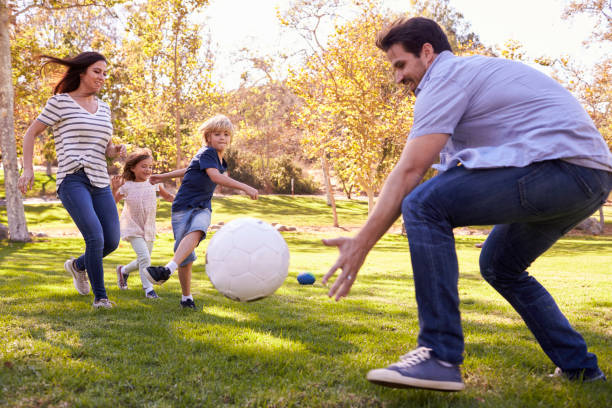 istock Family Playing Soccer In Park Together 660353432