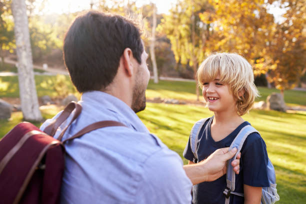 istock Father Fastening Son's Backpack As They Get Ready For Hike 660353444