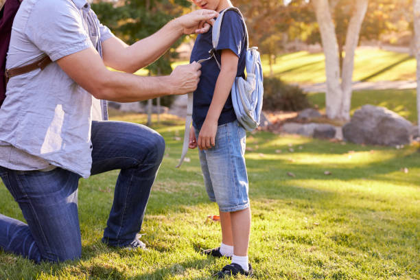 istock Father Fastening Son's Backpack As They Get Ready For Hike 660353450