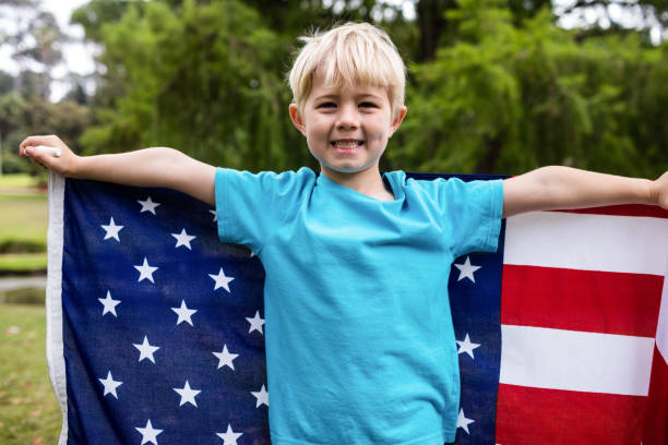 istock Boy holding an american flag in the park 660355688