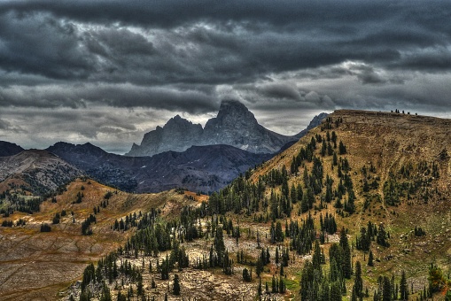 The west face of the Tetons rise into dramatic skies