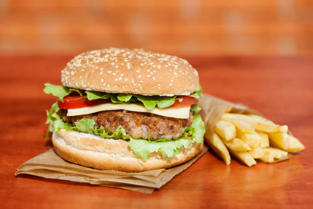Fresh tasty burger and french fries on wooden table