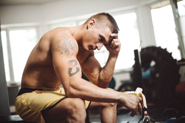 istock Muscular athlete on daily workout in gym, exercising with weights 660372970