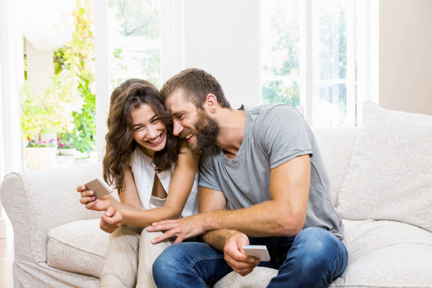 istock Smiling young couple looking at mobile phone 660378156