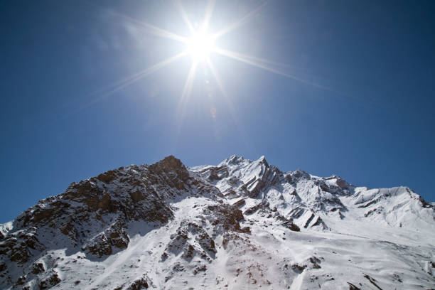 istock Sun shining with lens flare over snowcapped Himalayas mountain 660391276