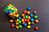 Multi colored chocolate covered candies on dark background