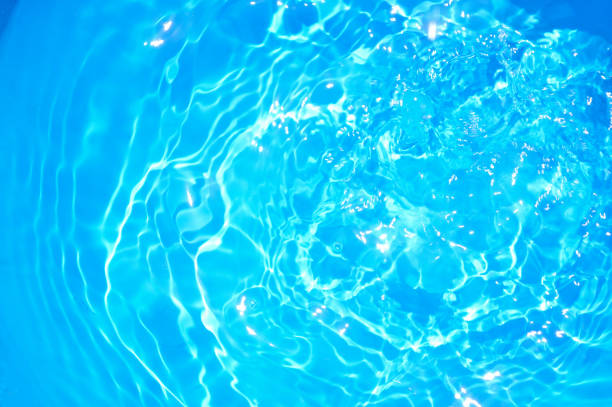 istock Blue pool water with sun reflections.Shining blue water ripple background. 660399984