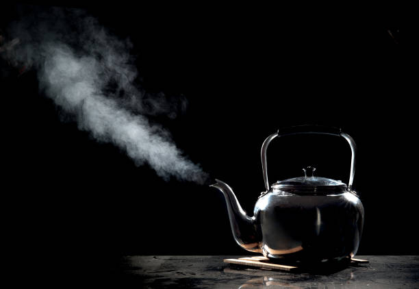istock Tea kettle with boiling water on a black background 660406282