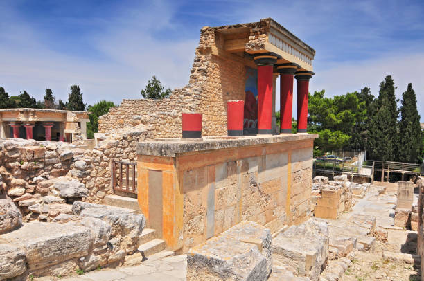 Minoan Palace of Knossos in Crete, Greece Partial view of the Minoan Palace of Knossos with characteristic columns and a fresco of a bull behind. Crete, Greece arhanes stock pictures, royalty-free photos & images