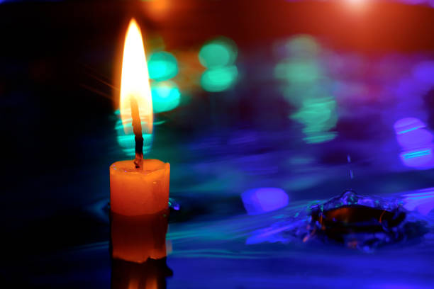 Candle light in the water with little water waves (water surface) in the pool on the twilight and light bokeh background.