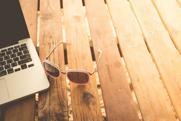 istock Labtop on wooden table at beach 660425806