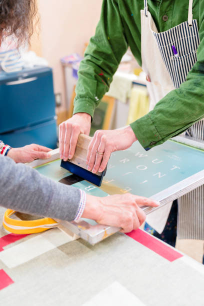 istock Designers working together to screen print a design 660439128