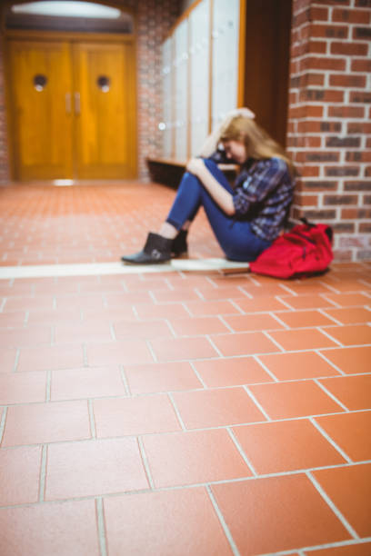 istock Thoughtful student sitting on the floor against the wall 660442208