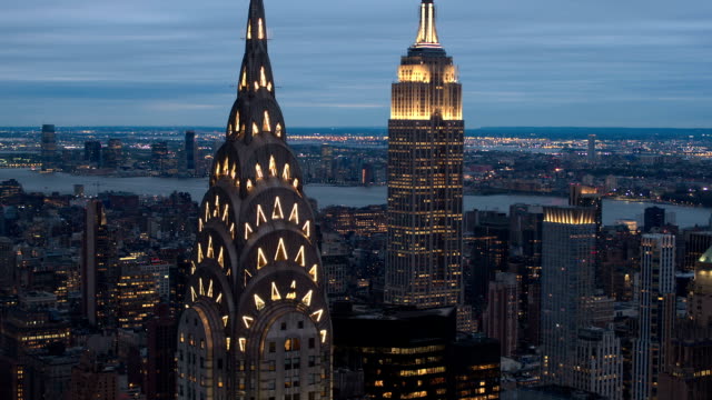 CLOSE UP, AERIAL: Scenic view of Midtown Manhattan, Chrysler Building top lit up in the dark and New Jersey in the background