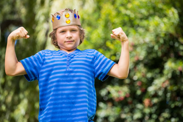 istock Cute boy with a crown showing his muscles 660452600