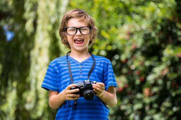 istock Cute boy with glasses holding a camera 660452812