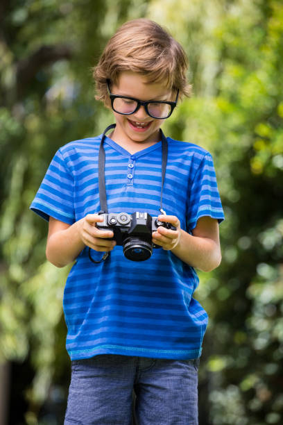 istock Cute boy with glasses holding and looking a camera 660452850