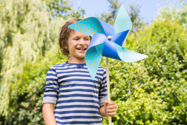 istock Cute boy smiling and holding a windmill 660453580