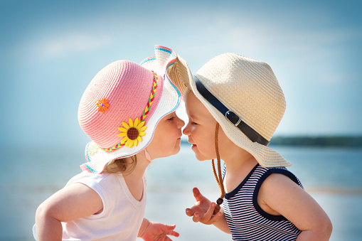 Bebita y babyboy de besos en la playa photo