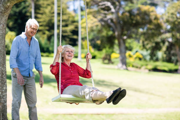istock Senior man pushing his partner on swing 660461806