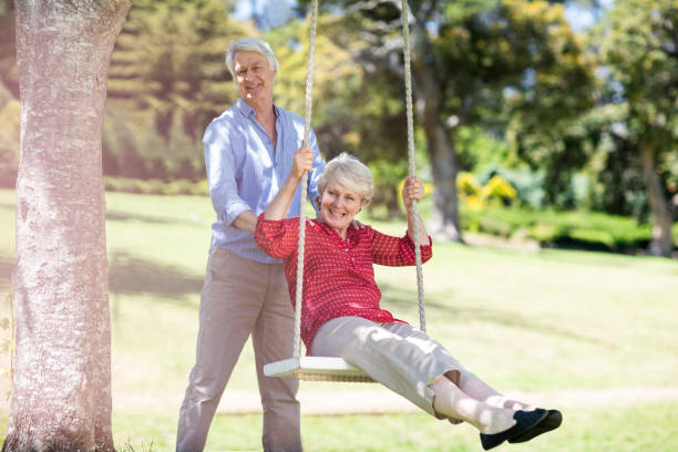 istock Senior man pushing his partner on swing 660462020