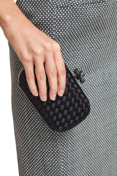 istock Girl holding a black clutch on an isolated white background 660462282