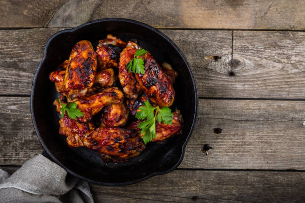 куриные крылышки в чугунной сковороде - wing spicy chicken wings sauces chicken стоковые фото и изображения