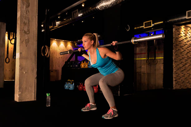 istock sporty girl squats with barbell training 660489768