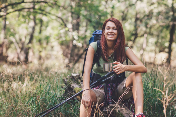 istock Smiling tourist sitting on a fallen tree in the forest 660490078