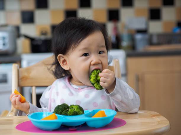 niña comiendo vegetales primera vez - baby carrot fotografías e imágenes de stock