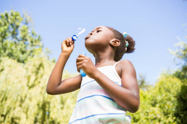 istock Cute mixed-race girl smiling and playing with bubbles 660506836