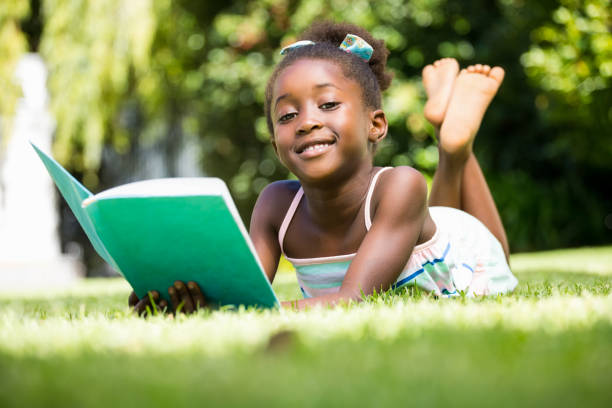 istock Smiling mixed-race girl lying and holding a book 660507218
