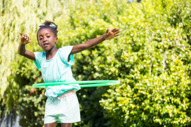 Cute mixed-race girl playing with a hoop