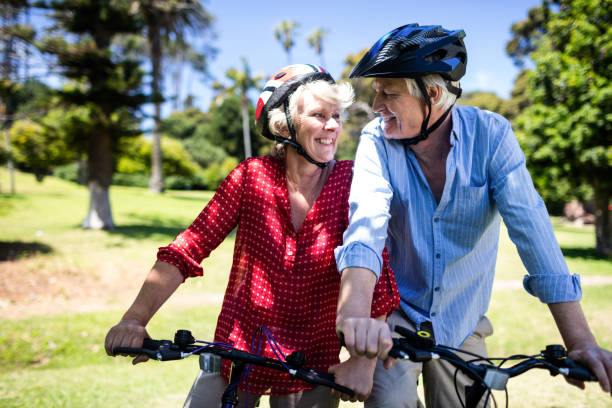 istock Happy couple riding a bicycle in park 660524024