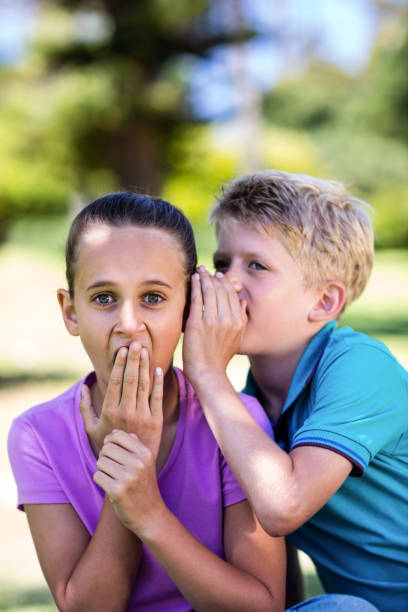 istock Boy whispering in his sisters ear 660527254