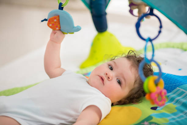 istock Baby boy lying and playing with toys 660527348