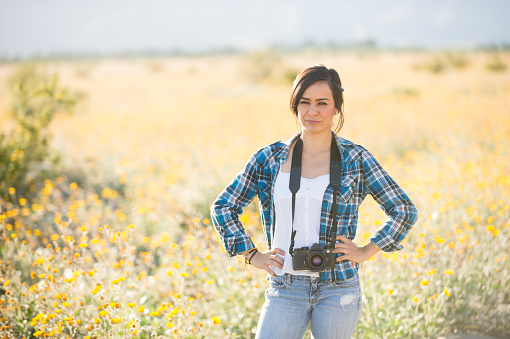 A Hispanic women photographer, photographing the wild flowers.  Super bloom in the spring.