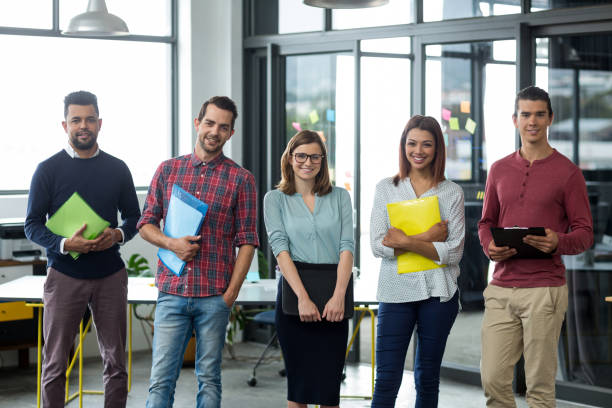 istock Smiling businesspeople standing with file and clipboard in office 660540276