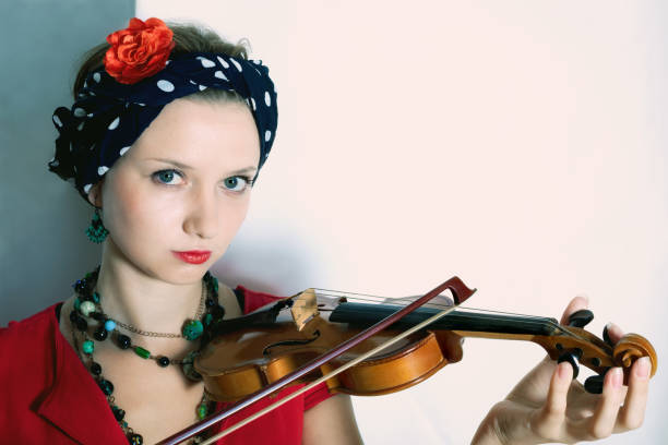 istock Young woman with violin on light background 660541352