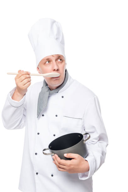 istock 30-year-old novice cook eat with a spoon from the pan on a white background 660541378