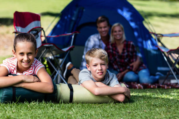 istock Siblings lying on grass outside the tent 660564170