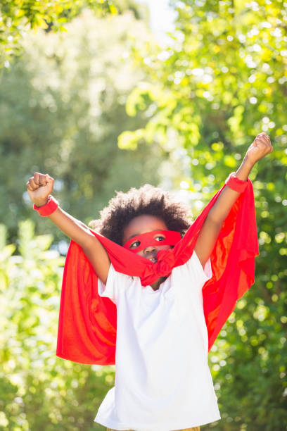 istock Boy dressed as a super hero in a park 660567020