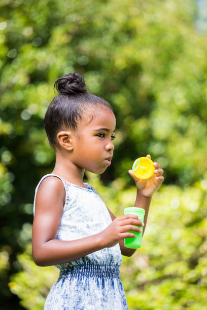 istock Little girl making bubble in a park 660569410