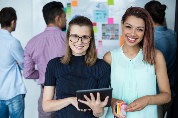 istock Business executives standing with digital tablet and coffee cup in office 660573728